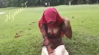 Menggoda Di Taman Dengan Hijab Yang Menonjolkan Lekuk